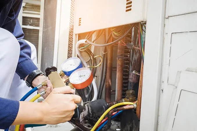 Technician checking refrigerant gauges on a residential heating and cooling system